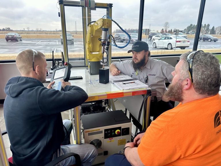 Apprentice learning robotic programming alongside a senior engineer at Alliance Automation.