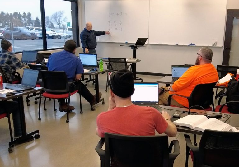Apprentices in a classroom learning automation theory from an Alliance Automation instructor.